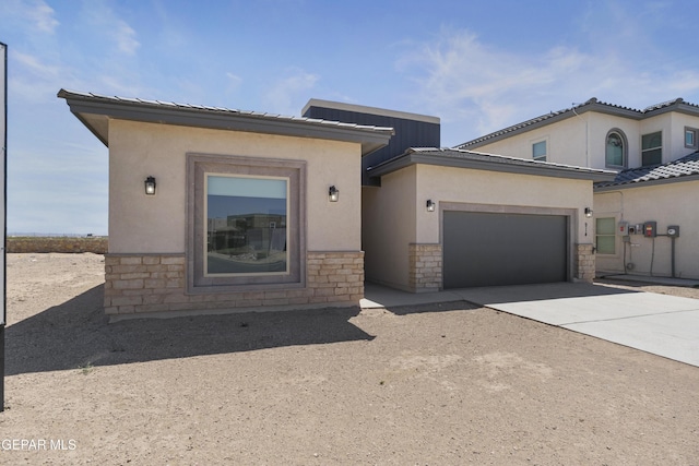 view of front facade featuring an attached garage, stucco siding, stone siding, and driveway