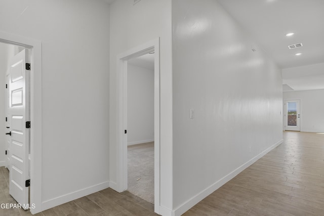 hallway featuring recessed lighting, baseboards, visible vents, and wood finished floors