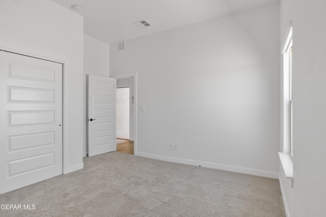 unfurnished bedroom with carpet, visible vents, and baseboards