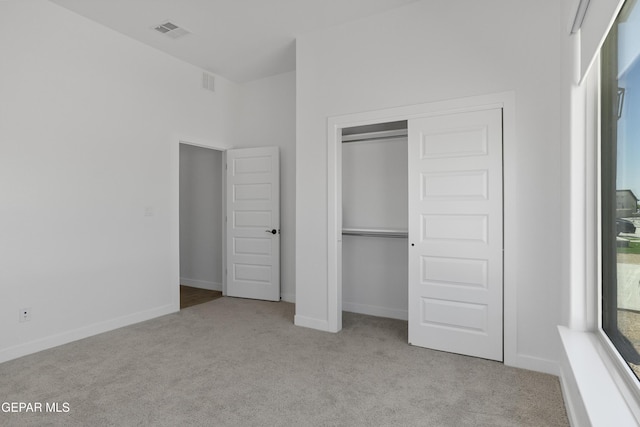 unfurnished bedroom featuring carpet flooring, a closet, visible vents, and baseboards