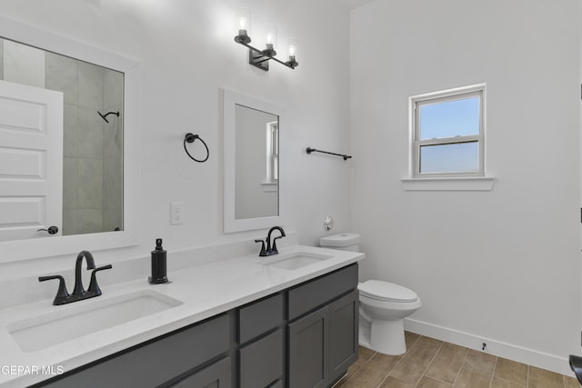 full bath featuring a sink, toilet, baseboards, and wood finished floors