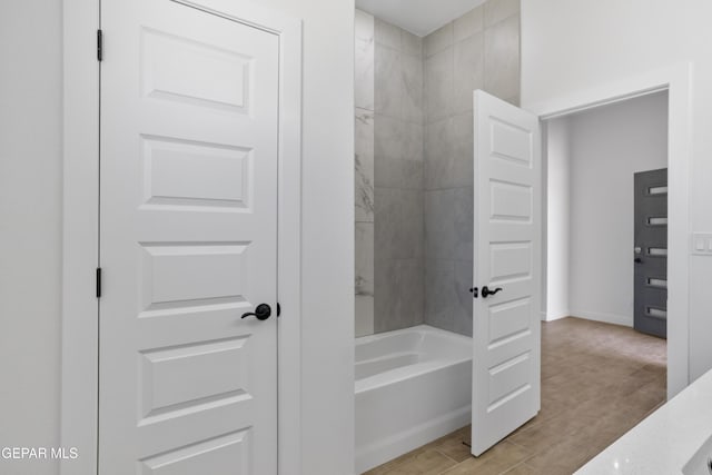 bathroom featuring bathing tub / shower combination and baseboards