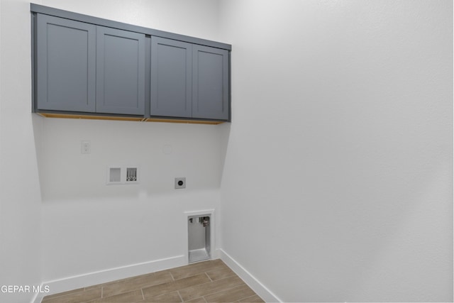 laundry room with electric dryer hookup, cabinet space, hookup for a washing machine, baseboards, and wood finish floors