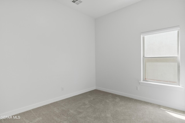 spare room featuring carpet, baseboards, and visible vents