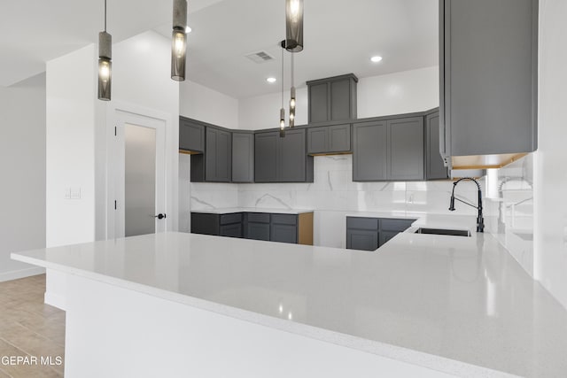 kitchen with recessed lighting, visible vents, a sink, a peninsula, and decorative backsplash