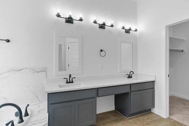 bathroom with baseboards, double vanity, a sink, and wood finished floors