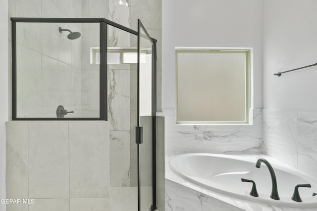 bathroom featuring a bath and a shower stall