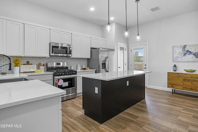 kitchen featuring visible vents, a sink, light countertops, appliances with stainless steel finishes, and decorative backsplash