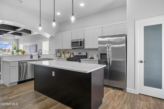 kitchen with tasteful backsplash, a peninsula, recessed lighting, stainless steel appliances, and a kitchen island