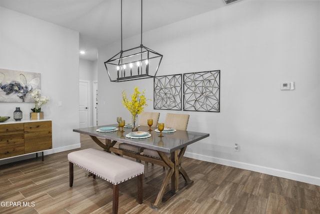 dining area featuring a chandelier, wood finished floors, and baseboards