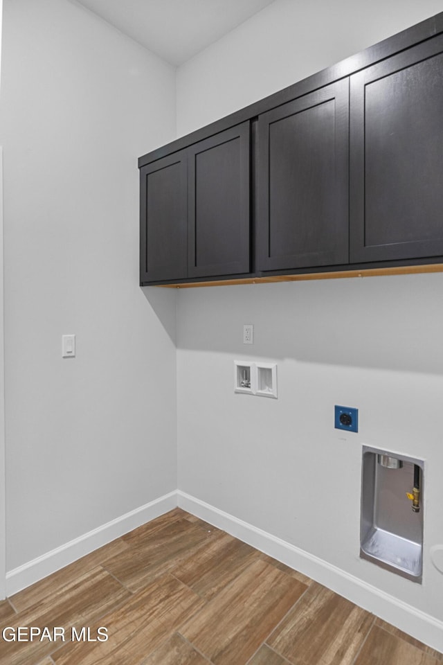 laundry room featuring light wood-type flooring, hookup for an electric dryer, washer hookup, and cabinet space