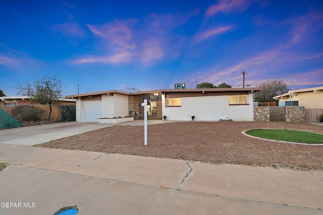 ranch-style home with fence, a garage, and concrete driveway