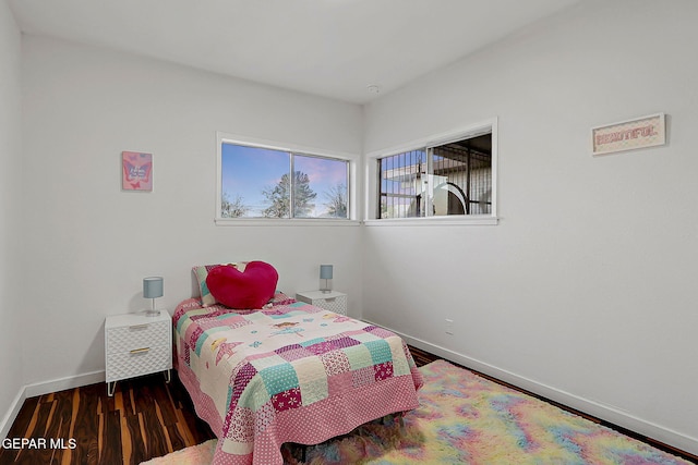 bedroom with baseboards and wood finished floors