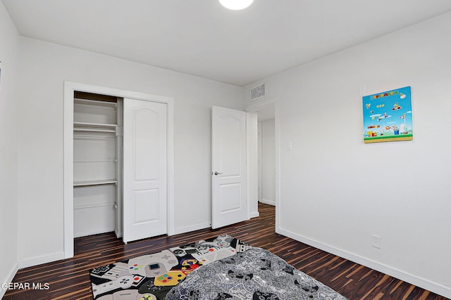 unfurnished bedroom featuring visible vents, baseboards, a closet, and dark wood-style floors
