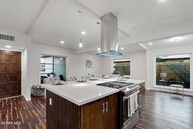 kitchen featuring island exhaust hood, stainless steel range with gas stovetop, dark wood-style floors, and visible vents
