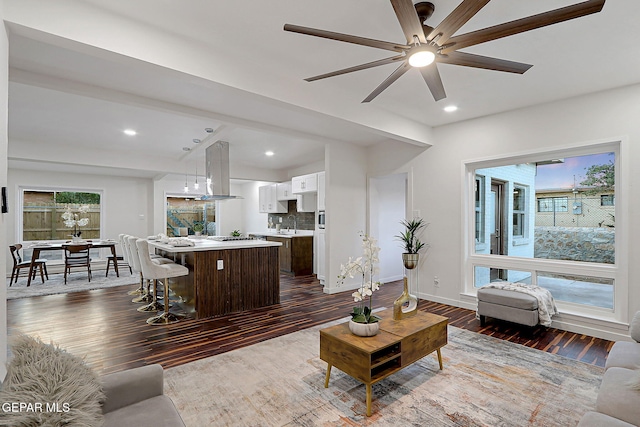 living room with dark wood-type flooring, a healthy amount of sunlight, ceiling fan, and recessed lighting