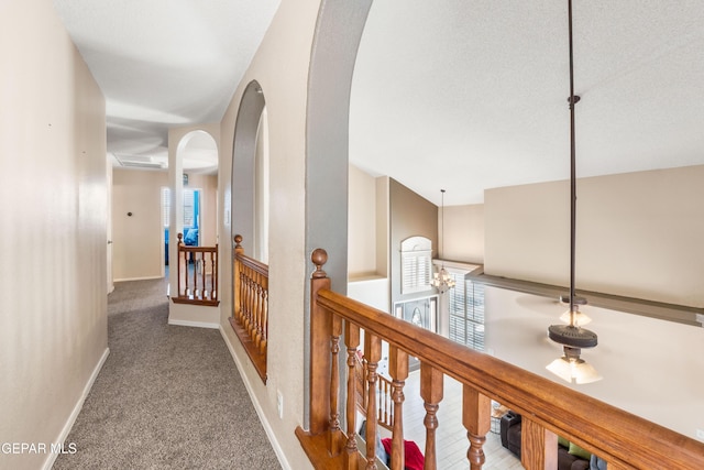 400 Rio Fango, El Paso, TX 79932 - hall featuring baseboards, arched walkways, a notable chandelier, an upstairs landing, and carpet floors
