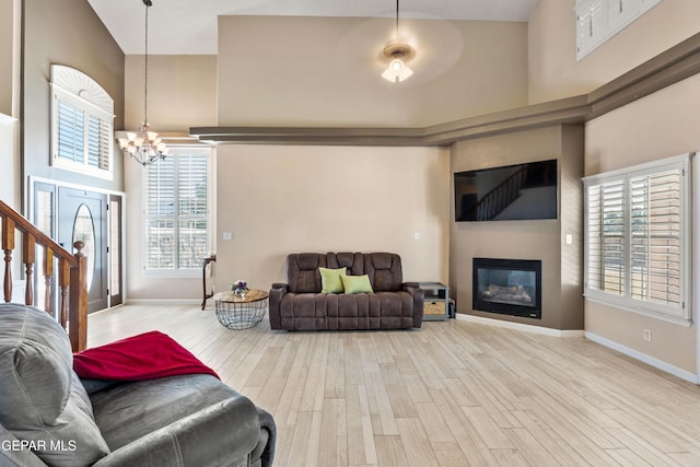400 Rio Fango, El Paso, TX 79932 - living room with a high ceiling, an inviting chandelier, baseboards, and wood finished floors
