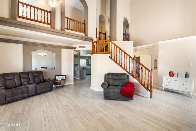 400 Rio Fango, El Paso, TX 79932 - living area featuring arched walkways, stairway, a high ceiling, wood finished floors, and baseboards
