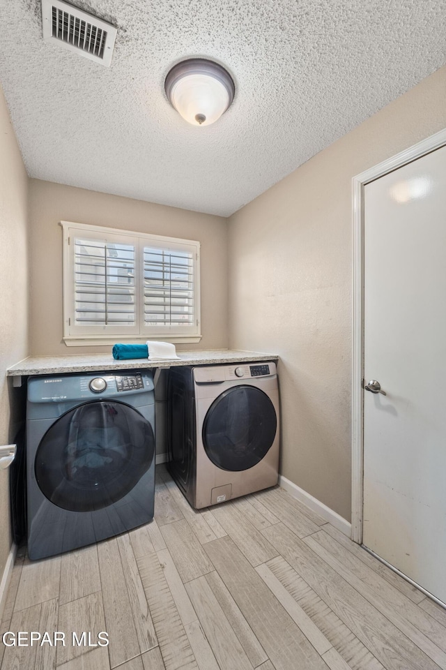 400 Rio Fango, El Paso, TX 79932 - laundry room featuring laundry area, a textured ceiling, visible vents, light wood finished floors, and washer and clothes dryer
