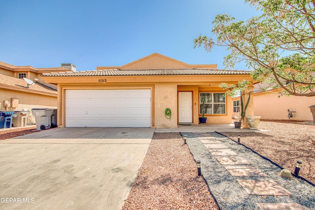 view of front of property featuring a tile roof, driveway, a garage, and stucco siding