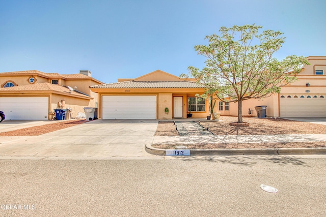 view of front of property with concrete driveway, stucco siding, a chimney, an attached garage, and a tiled roof
