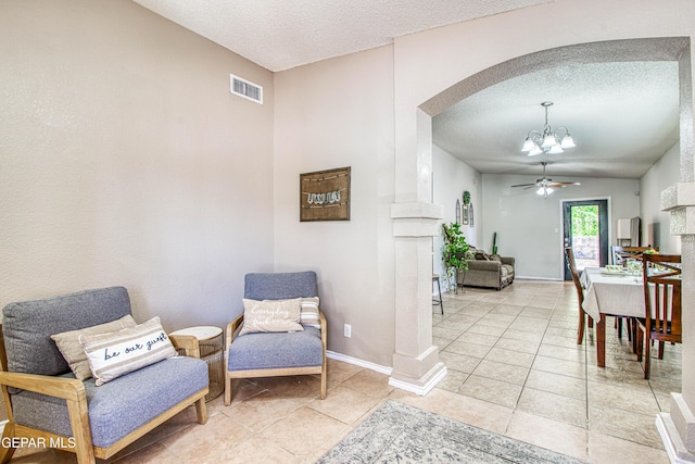 interior space featuring arched walkways, light tile patterned floors, visible vents, and a textured ceiling