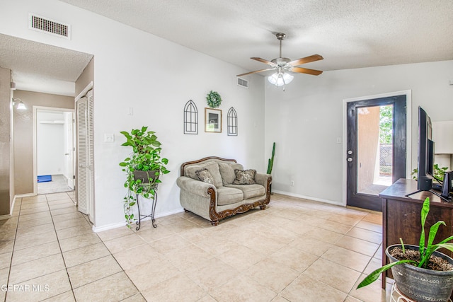 sitting room with visible vents, a ceiling fan, light tile patterned floors, and a textured ceiling