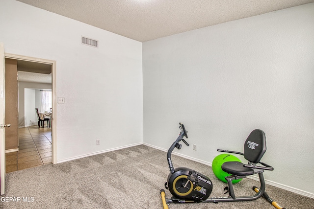 workout room featuring visible vents, baseboards, carpet floors, and a textured ceiling