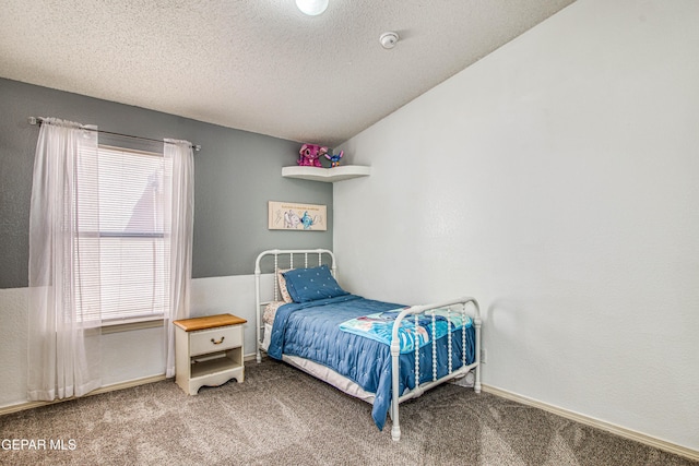 carpeted bedroom with a textured ceiling and baseboards