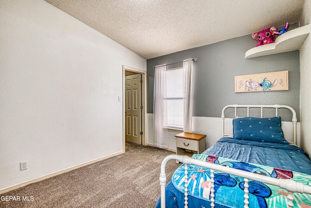 bedroom with a textured wall, carpet, a textured ceiling, and baseboards