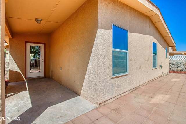 property entrance with a patio area and stucco siding