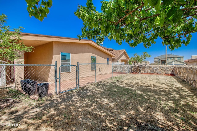 view of yard with a fenced backyard and a gate