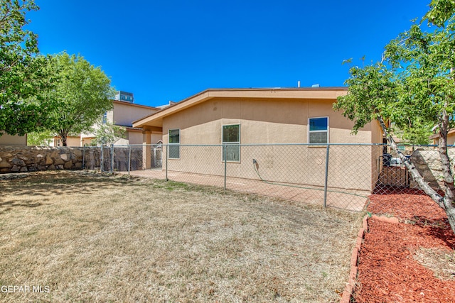 view of home's exterior with a yard, fence, and stucco siding
