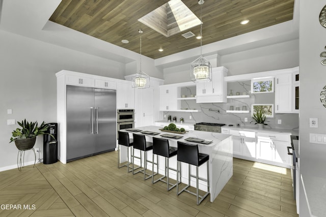 784 Brunswick Pl, Horizon City, TX 79928 - kitchen featuring open shelves, appliances with stainless steel finishes, wood ceiling, backsplash, and a skylight