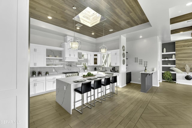 784 Brunswick Pl, Horizon City, TX 79928 - kitchen with a breakfast bar, a chandelier, backsplash, open shelves, and white cabinets