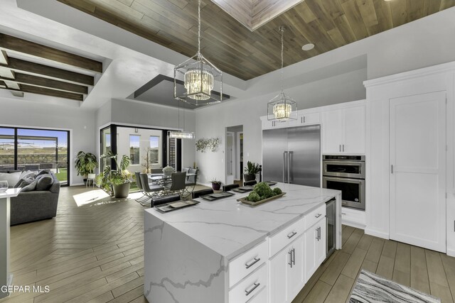 784 Brunswick Pl, Horizon City, TX 79928 - kitchen with a notable chandelier, open floor plan, wood finished floors, stainless steel appliances, and a kitchen island