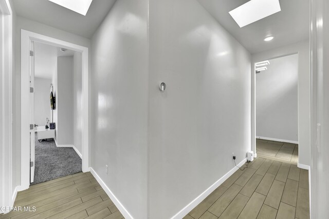 784 Brunswick Pl, Horizon City, TX 79928 - hallway featuring a skylight, light wood-style floors, and baseboards
