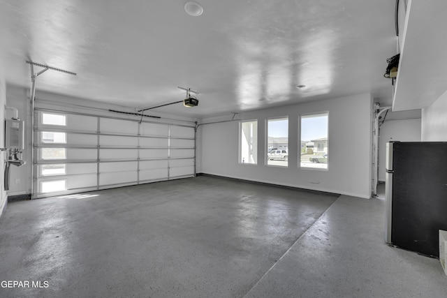 784 Brunswick Pl, Horizon City, TX 79928 - garage with baseboards, freestanding refrigerator, and a garage door opener
