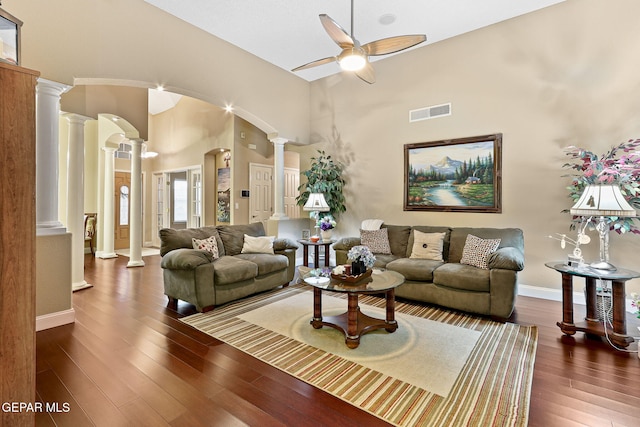 living room with a ceiling fan, visible vents, decorative columns, arched walkways, and wood finished floors