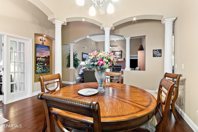 dining space with ornate columns, arched walkways, visible vents, baseboards, and hardwood / wood-style flooring