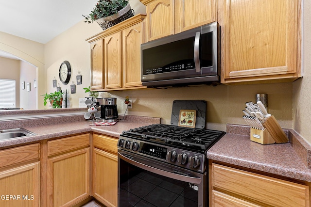 kitchen featuring a sink, light brown cabinetry, and stainless steel appliances