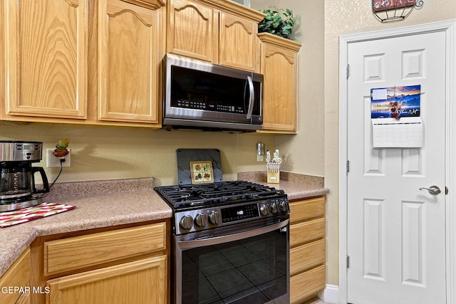 kitchen with light countertops, light brown cabinetry, and stainless steel appliances