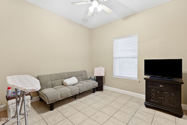 living room with light tile patterned flooring, ceiling fan, and baseboards
