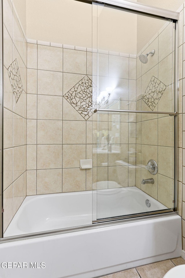 bathroom featuring tile patterned floors and enclosed tub / shower combo