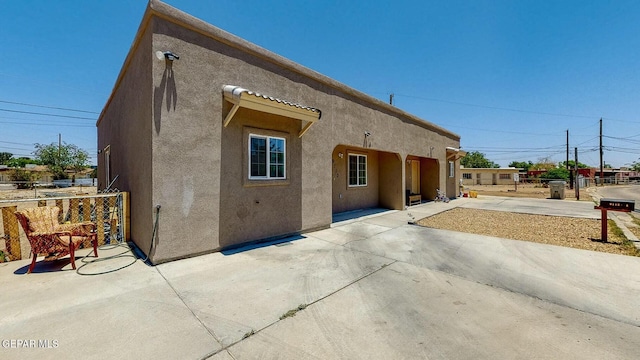 rear view of house with a patio and stucco siding