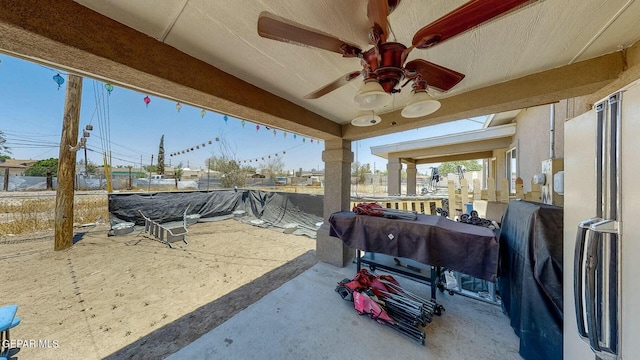 view of patio featuring grilling area, fence, and a ceiling fan