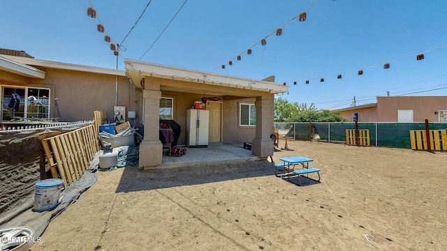 back of property featuring fence, a patio, and stucco siding