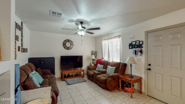 living area with visible vents, ceiling fan, light tile patterned floors, and a textured ceiling