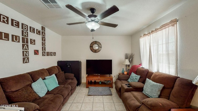 living room with light tile patterned floors, visible vents, and a ceiling fan